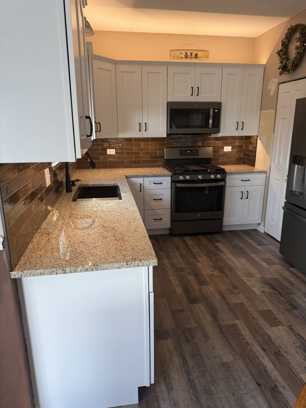 White kitchen cabinetry arranged around a black range