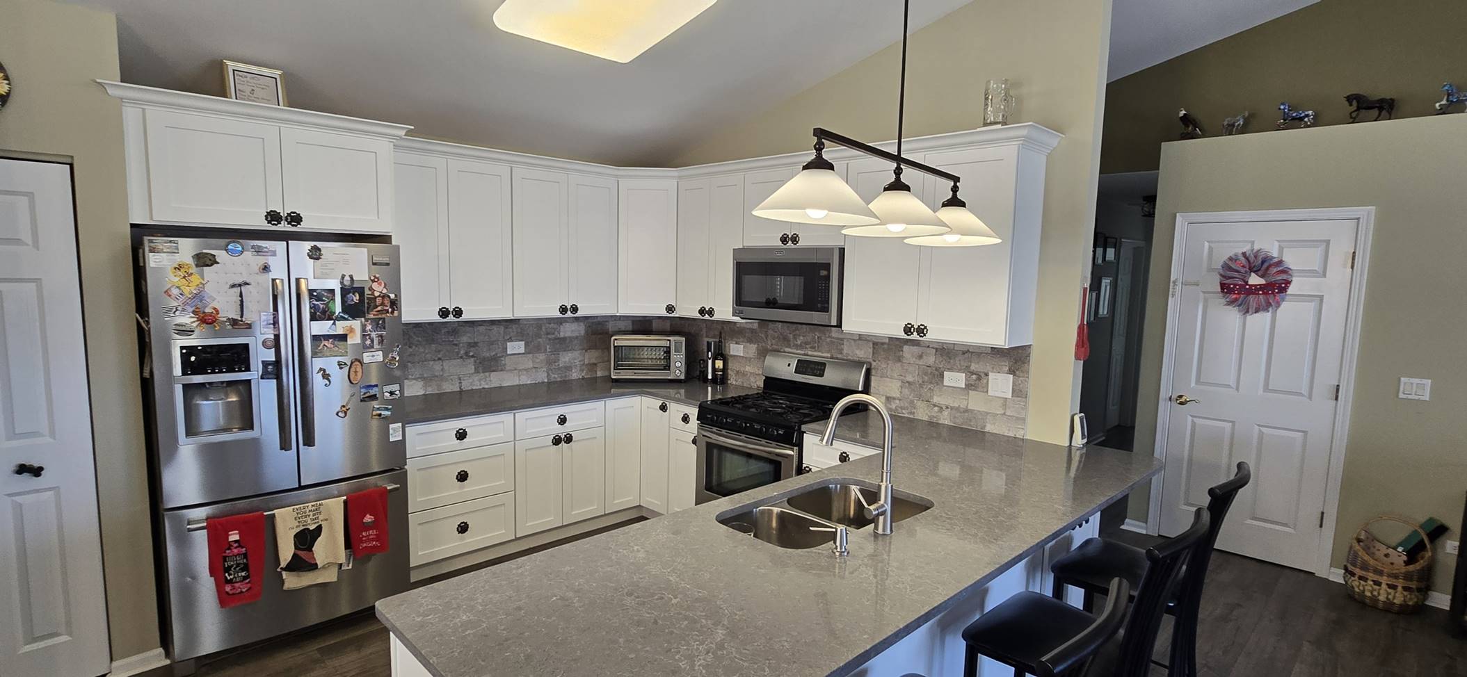 White kitchen with a peninsula and pendant lighting
