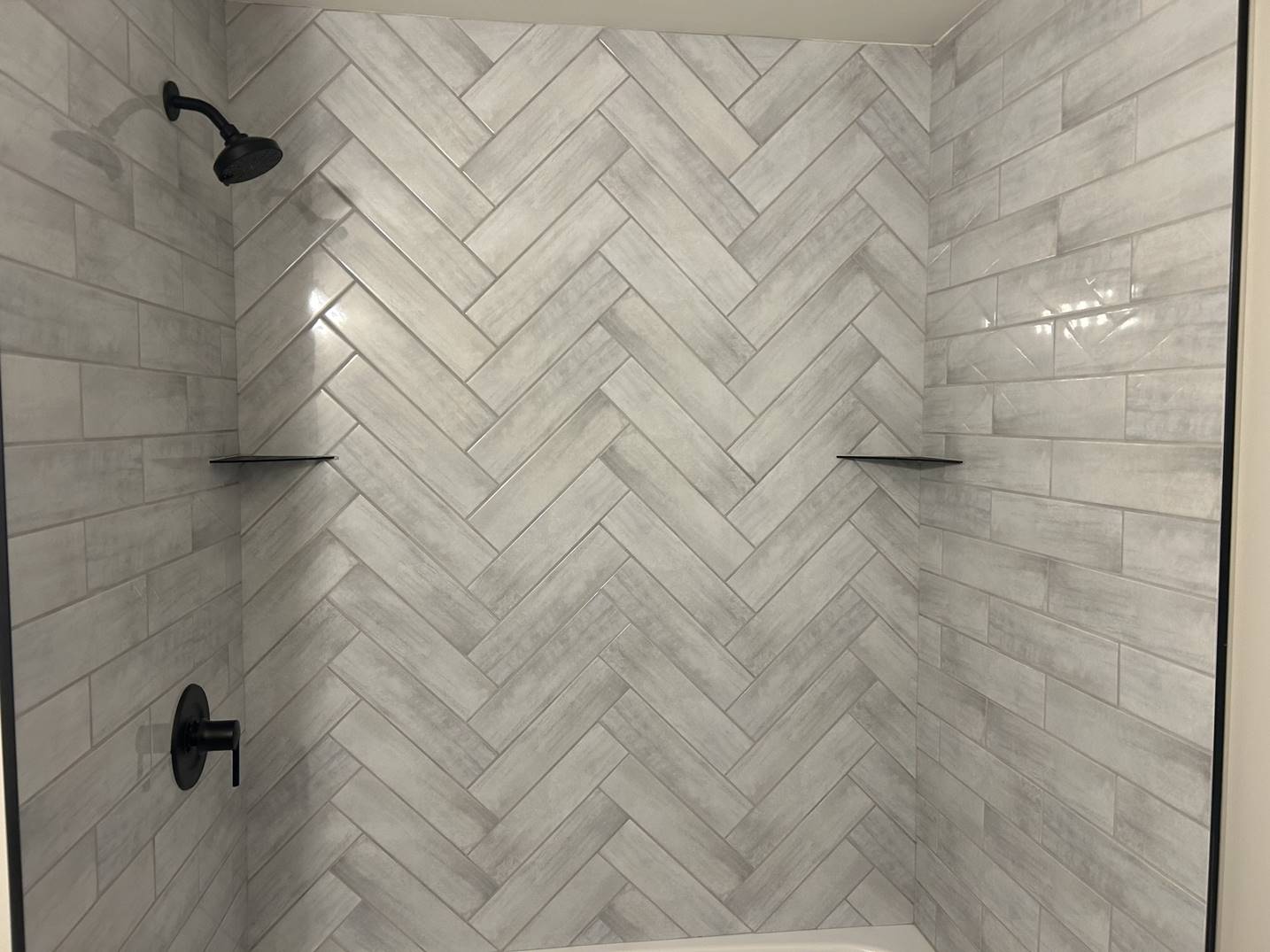 Herringbone-tile walk-in shower completed by SHAY Construction